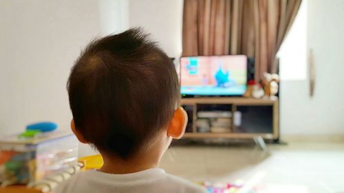 Close-up of young boy watching tv