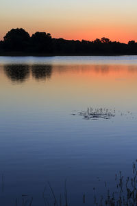 Scenic view of lake against sky at sunset