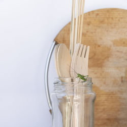 Close-up of glass jar on table against white background