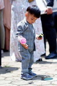 Portrait of boy standing on footpath