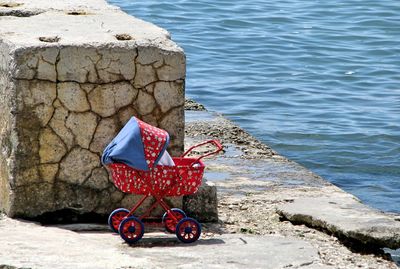 Man with red umbrella by sea