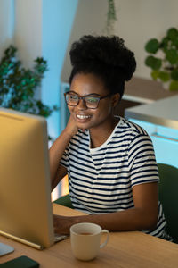 Happy african female, successful freelancer working on desktop computer, enjoying freelance life