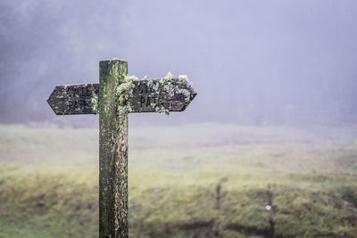 Cross on field against sky