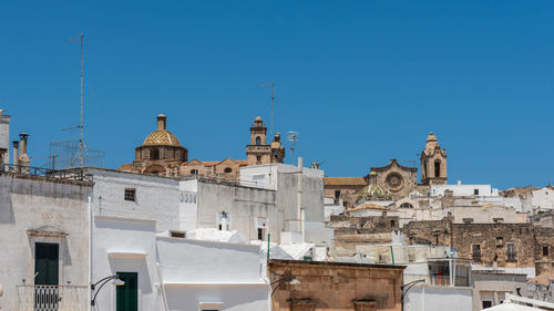 Low angle view of buildings against clear blue sky