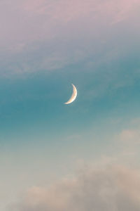 Low angle view of moon in sky at sunset