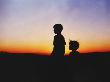 Silhouette of woman looking at sunset