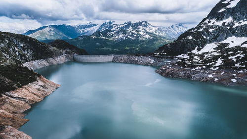 Scenic view of lake and snowcapped mountains against sky