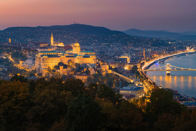 High angle view of illuminated buildings in city at sunset