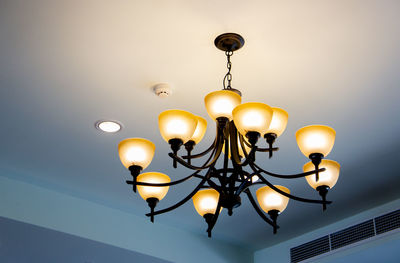 Low angle view of illuminated pendant lights hanging from ceiling