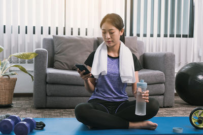 Young man using mobile phone while sitting on sofa