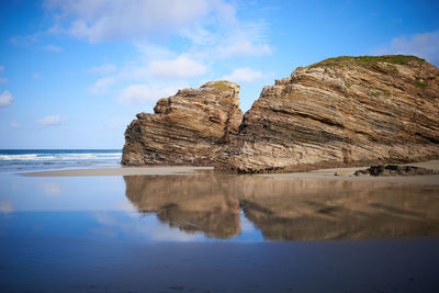 Scenic view of rocks in sea against sky