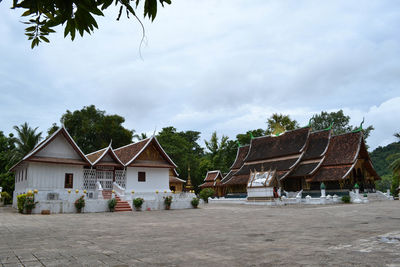 Houses by street against sky in village