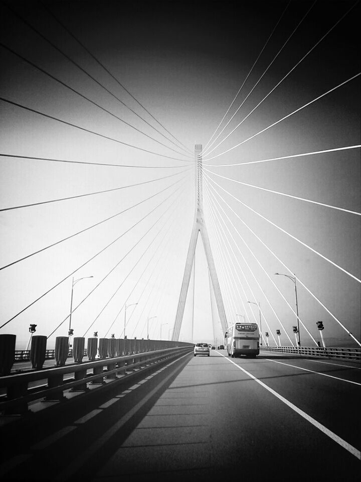 transportation, the way forward, diminishing perspective, vanishing point, connection, road marking, road, sky, built structure, illuminated, architecture, clear sky, travel, empty, no people, long, low angle view, cable, outdoors, highway