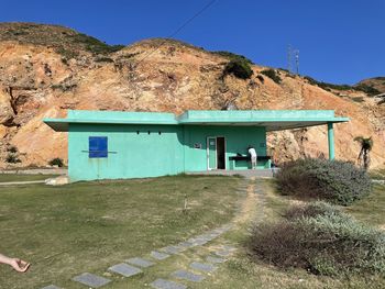 House on mountain against clear blue sky