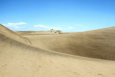 Scenic view of desert against clear blue sky