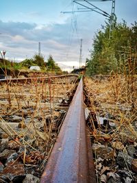 Railroad track amidst field against sky