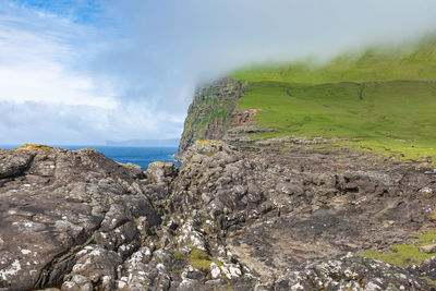 Scenic view of rocky mountains and sea against sky