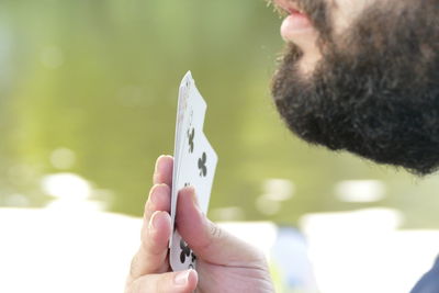 Midsection of young man playing cards