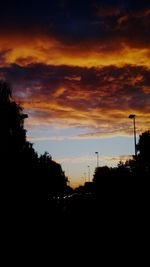 Silhouette of trees against cloudy sky