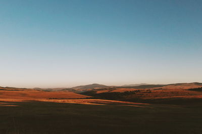 Scenic view of desert against clear blue sky