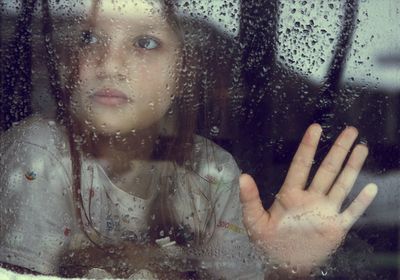 Portrait of young woman with reflection on window