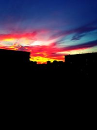 Silhouette buildings against sky during sunset