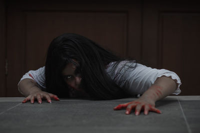 Portrait of young woman lying down on table