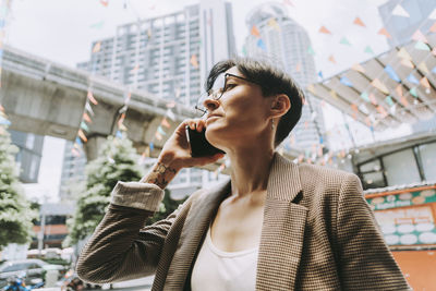 Businesswoman talking on smart phone in city