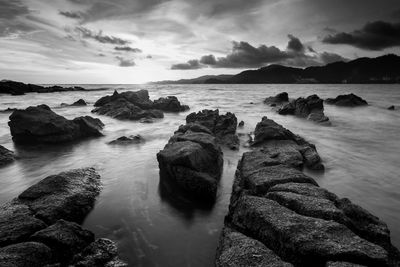 Scenic view of rocks in sea against sky