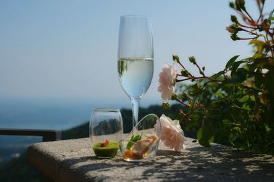 Glass on wine on wall against clear sky