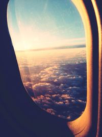 Cropped image of airplane flying over clouds