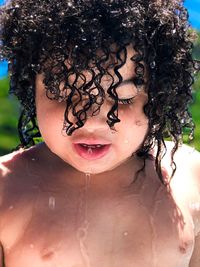 Close-up of shirtless boy with curly hair