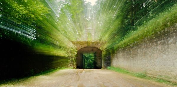 Blurred motion of road leading towards archway