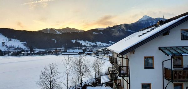 Houses and snowcapped mountains against sky