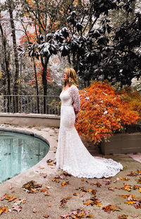 Woman standing by tree during autumn