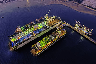 Aerial top view shipyard dry dock maintenance and repair container ship transport.