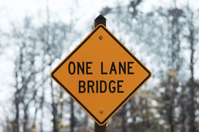 Low angle view of road sign against trees