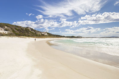 Full length of man walking on beach against sky