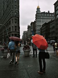 People with umbrella walking on street in city