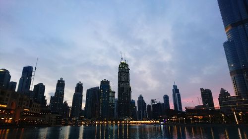 Illuminated buildings in city against sky