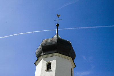 Low angle view of weather vane against blue sky