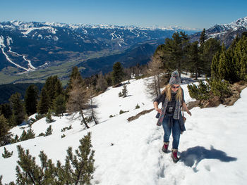 Full length of man walking on snow covered mountain