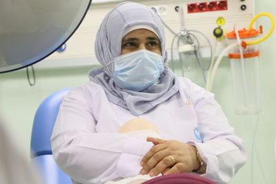 Midsection of doctor examining patient in clinic