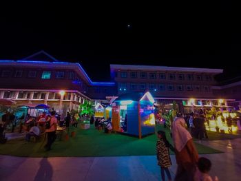 People on illuminated street at night