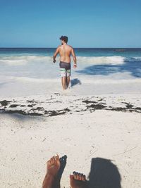 Full length of shirtless man on beach