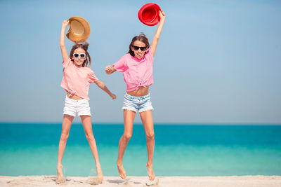 Rear view of women on beach against sky