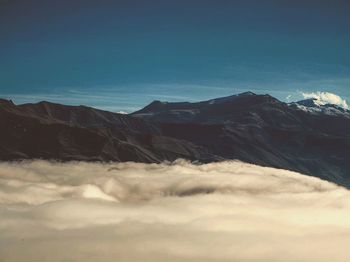 Scenic view of mountains against cloudy sky