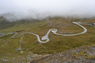 High angle view of text on road by mountain during foggy weather