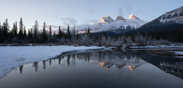 Panoramic winter sunrise shot from canadian rockies,three sisters mountain, canmore, alberta, canada