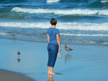 Rear view of friends standing on beach